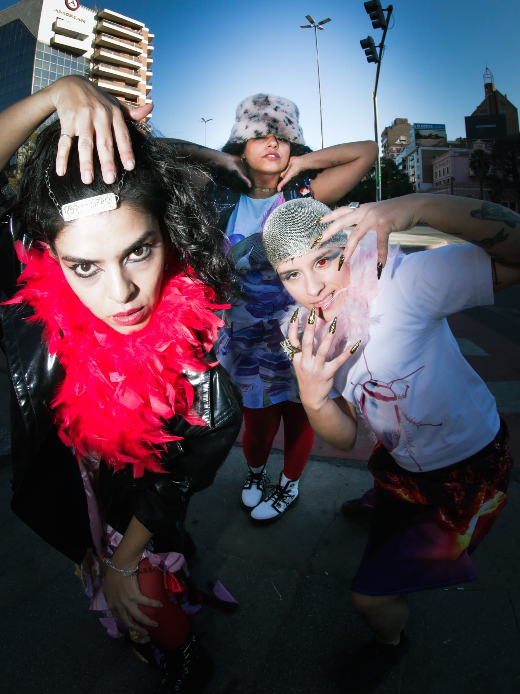 A group poses from below on the pavement: a red feather boa, a fur hat and altered clothing.